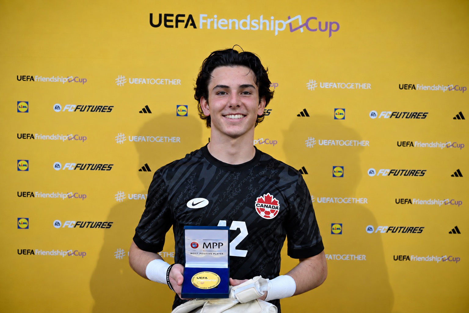 Ben MacKinnon holding the UEFA Friendship Cup Most Positive Player award